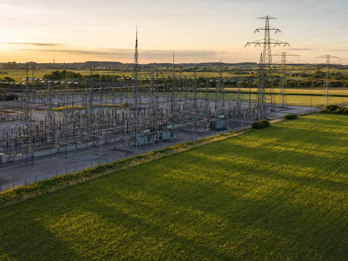 Umspannwerk direkt an einer grünen Wiese bei Sonnenuntergang